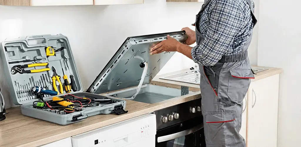 Handyman repairing a cooktop and checking wiring connections in Chattanooga, TN