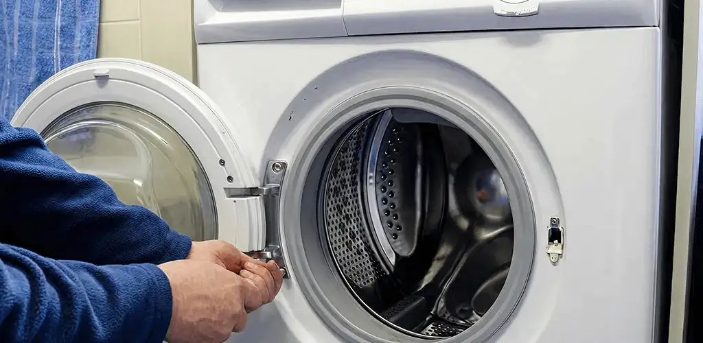 Washing machine repair handyman checking a front-load washer door and latch in Chattanooga, TN