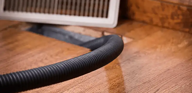 Air duct cleaning hose inserted into a floor vent for ductwork cleaning in Chattanooga, TN