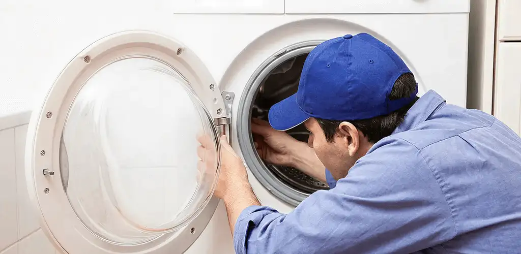 Washing machine repair handyman inspecting a front-load washer drum in Chattanooga, TN